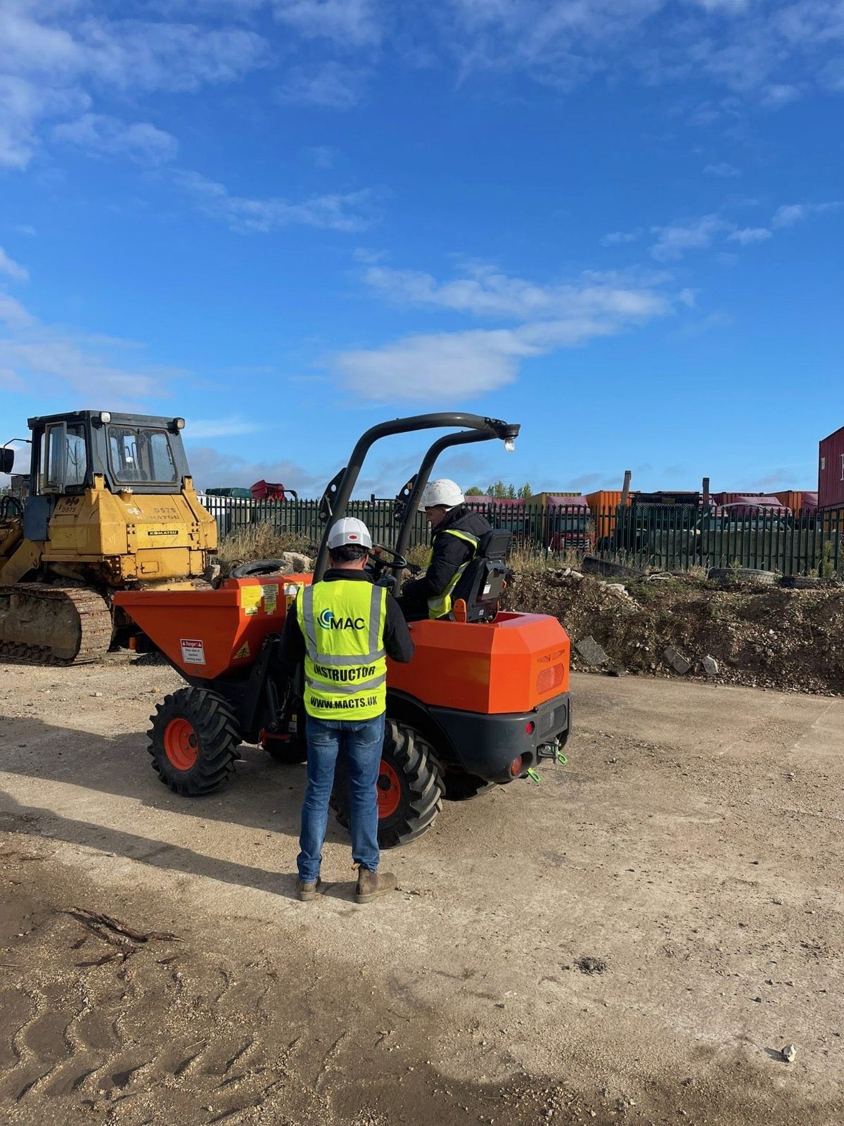 MAC instructor supervising a trainee on a forward tipping mini dumper on site