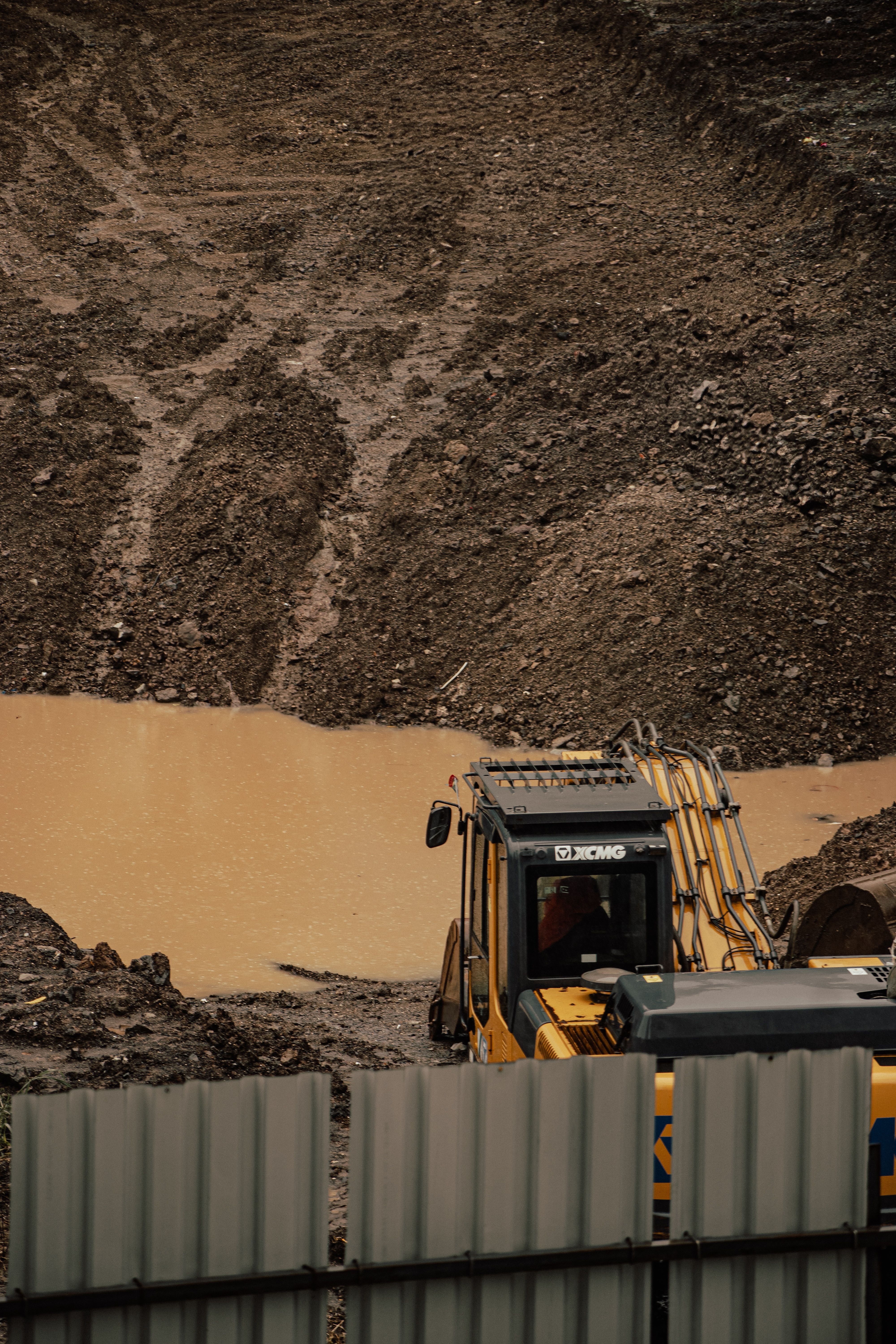 Tracked excavator working a muddy groundworks site