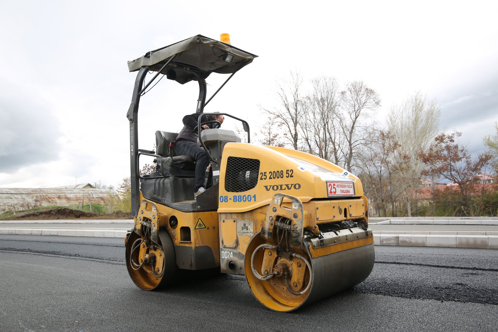 Road roller compacting fresh asphalt